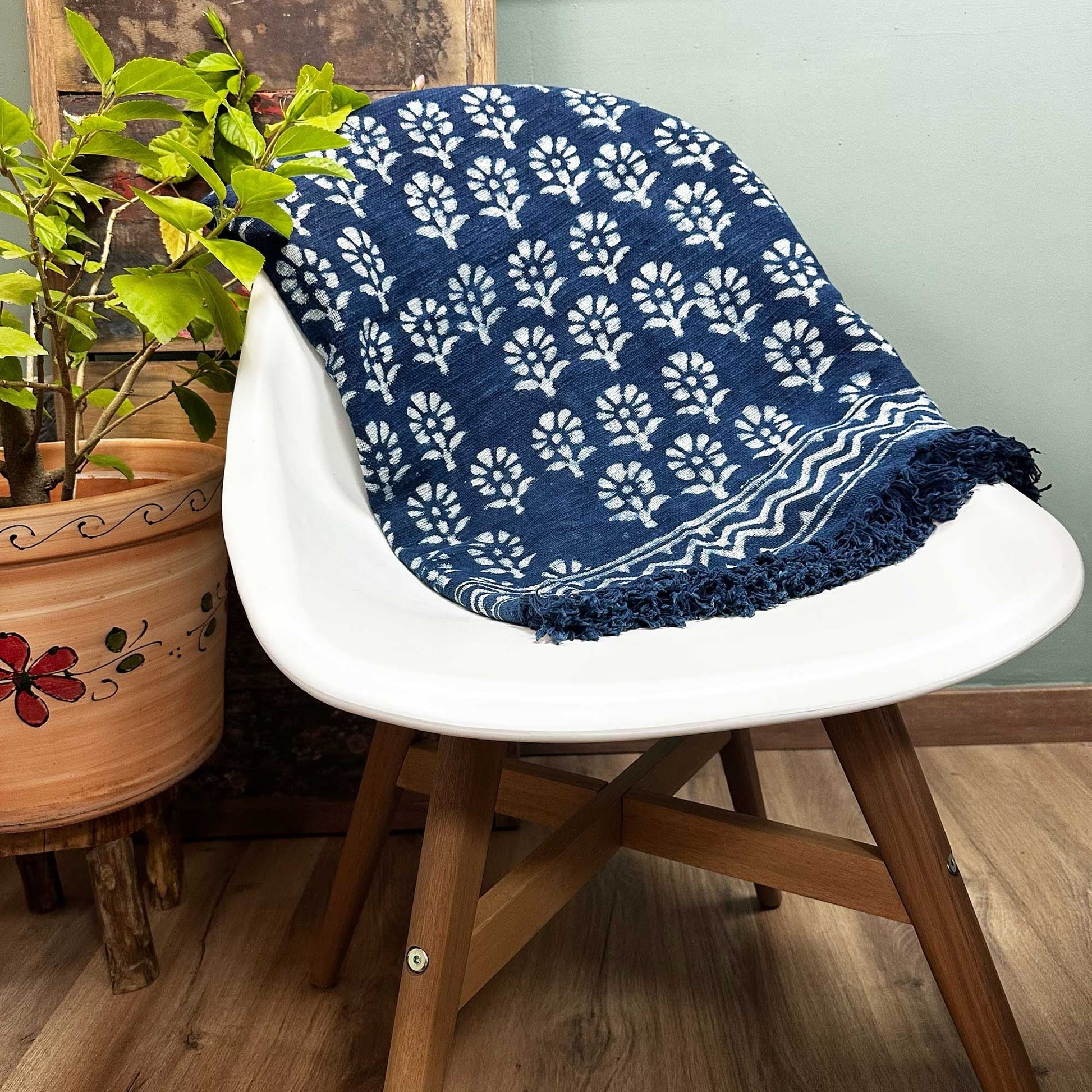 Manta Indigo hecha a mano – 170 × 120 CM – manta de algodón tejida a mano Chhota Flower con estampado floral blanco colocada sobre una silla