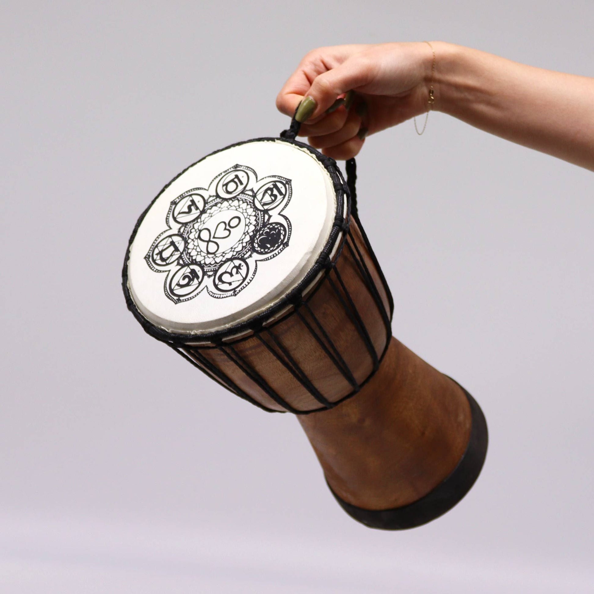 Alt Tag: Handmade Wide Top Djembe Drum – 30 CM held by hand, wide-top rope-tension Balinese carved drum with 30 cm playing surface