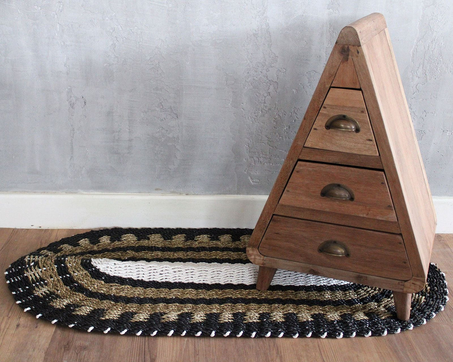 Alt Tag: Handwoven Seagrass Rug – Black & White Classic 60x120 CM oval black white tan woven rug under wooden drawer cabinet
