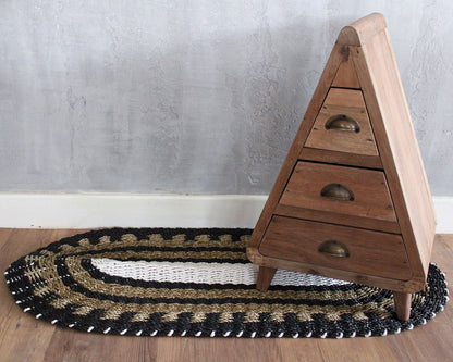 Alt Tag: Handwoven Seagrass Rug – Black & White Classic 60x120 CM oval black white tan woven rug under wooden drawer cabinet