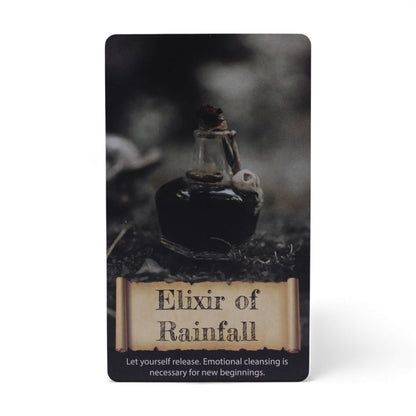 Alt Tag: Harmonizing Energy Oracle Cards – Insightful Deck card “Elixir of Rainfall” with dark glass bottle and scroll-style title