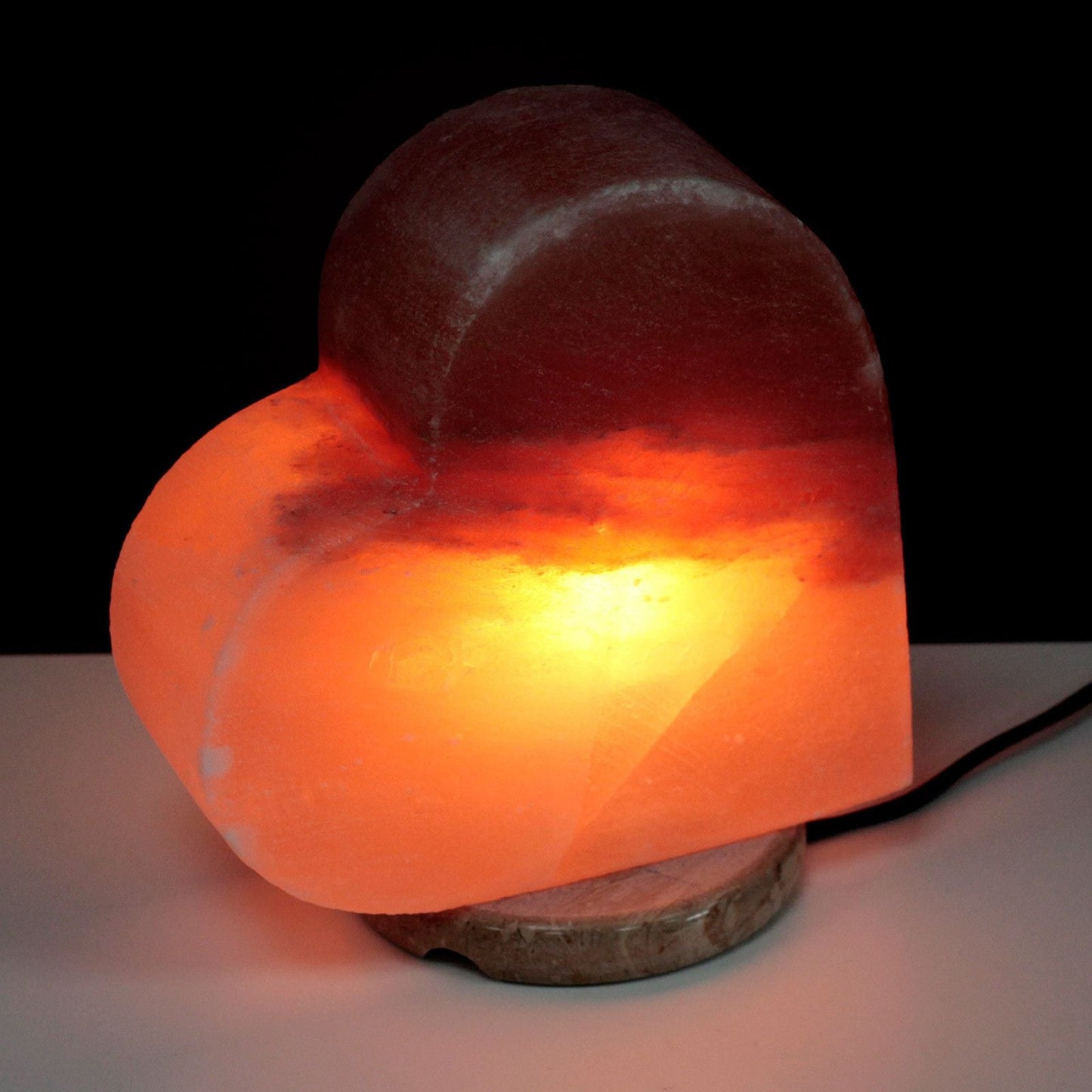 Alt Tag: Hjärtformad Himalaya-saltlampa, handskuren och tänd, med varmt orange-rosa sken