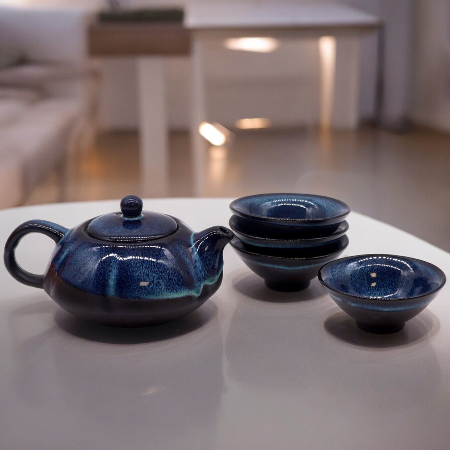 Alt Tag: Herbal Blues Teapot Set – Pot & Four Cups, handcrafted blue ceramic teapot with four matching cups on a table
