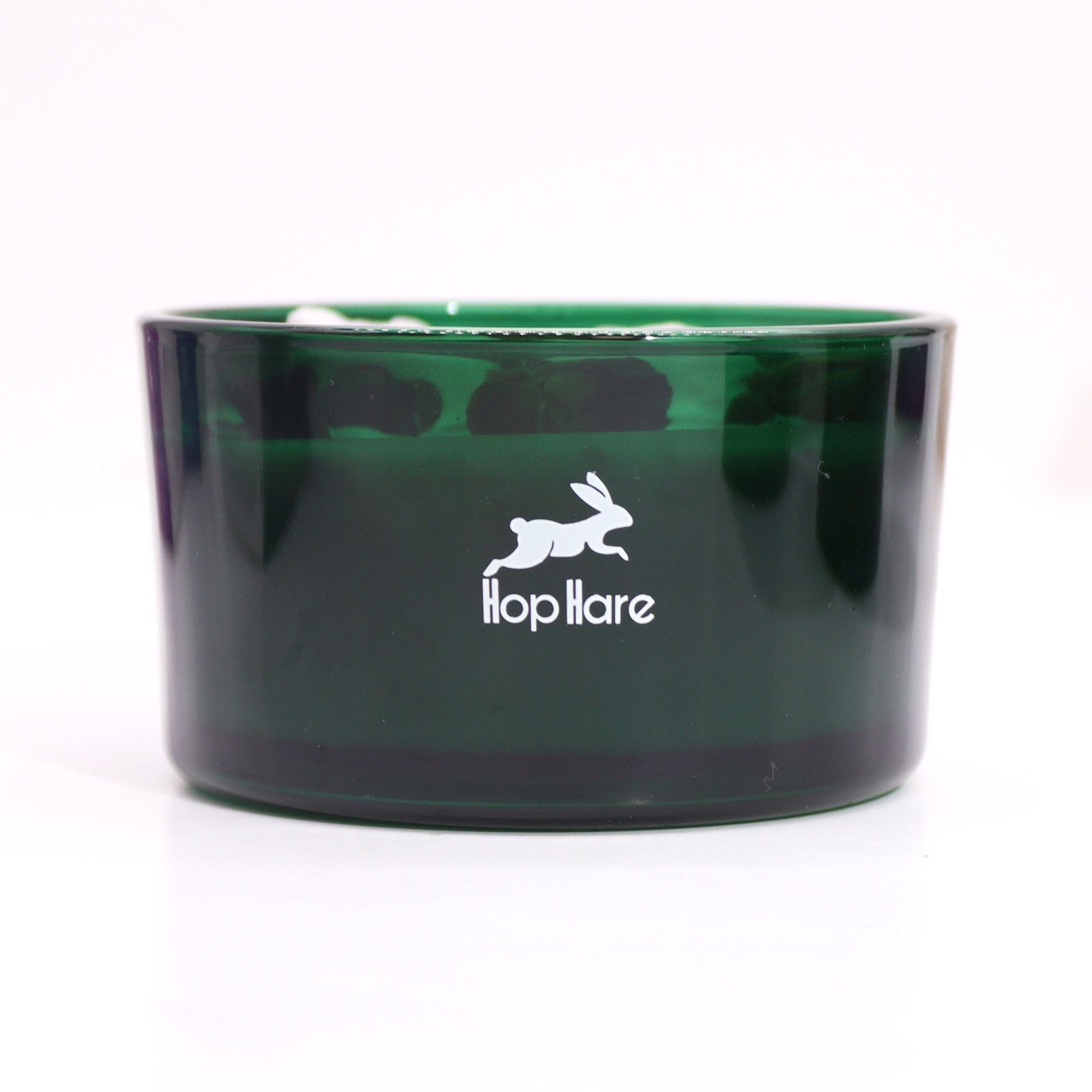 Alt-text: Hope Hare Crystal Magic Flower Candle – The Sun i grön glasburk med Hop Hare-logotyp