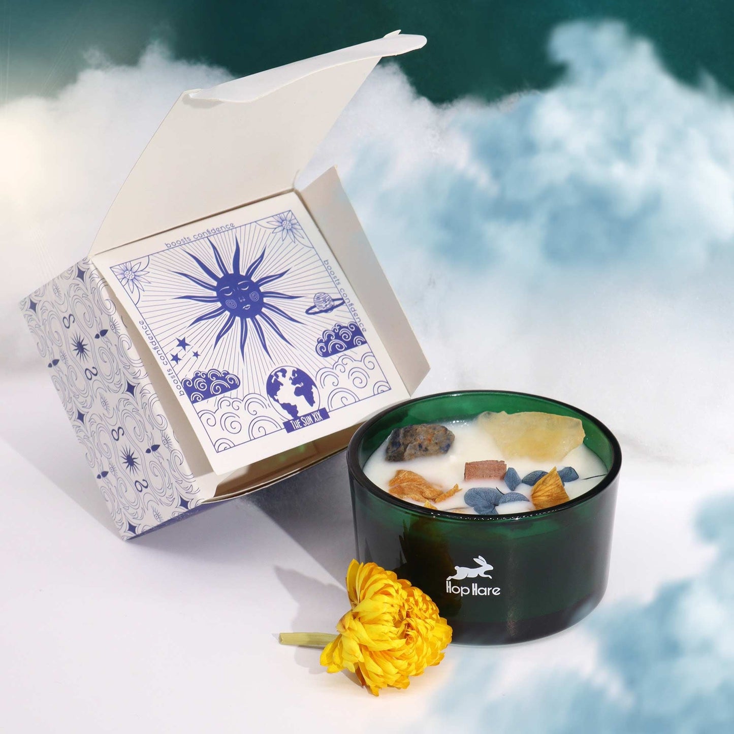 Hope Hare Crystal Magic Flower Candle – The Sun i grön glasburk med kristalltoppat vax, visad med produktförpackning och gul blomma