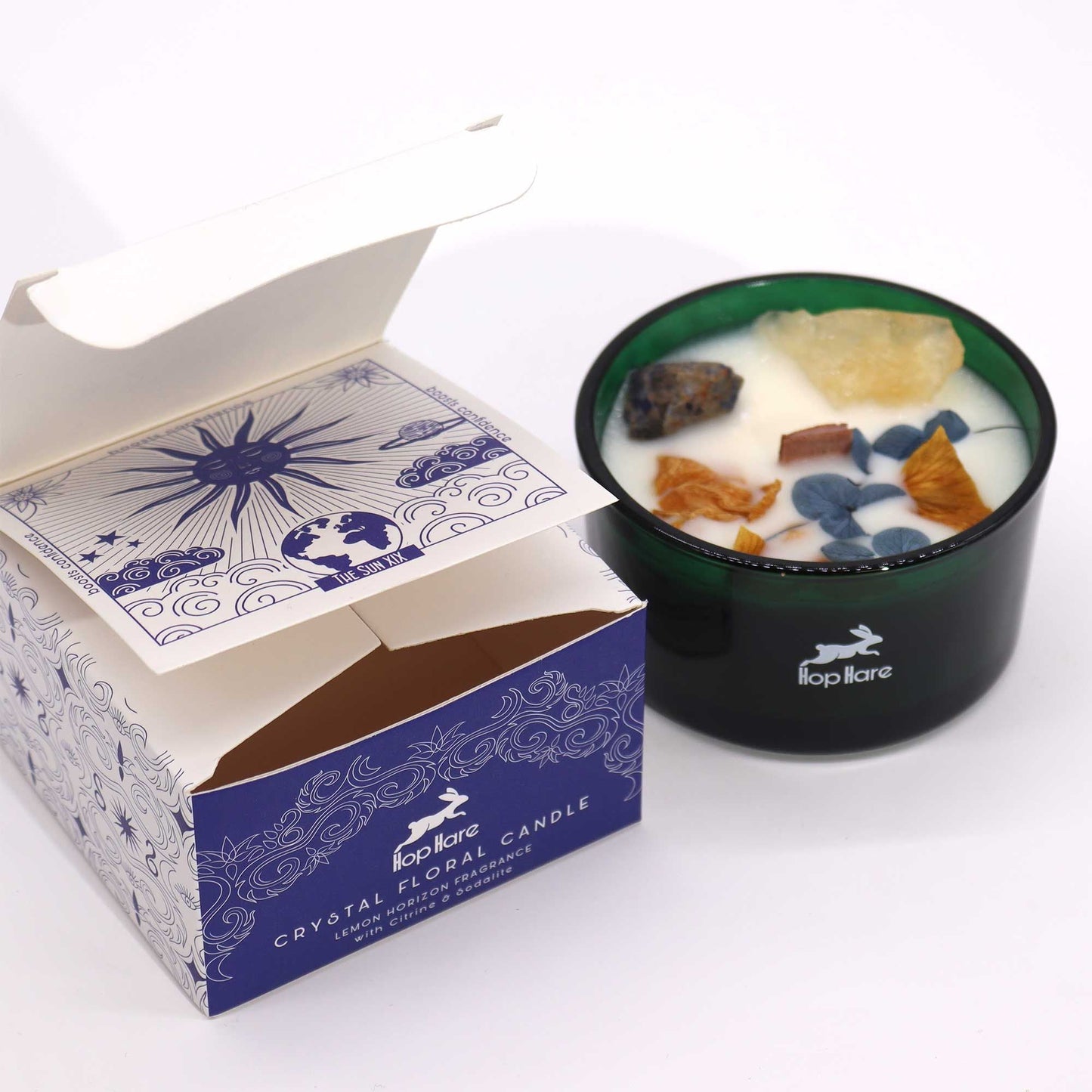Alt Tag: Hope Hare Crystal Magic Flower Candle – The Sun i grön glasburk med dekorativa kristaller och blomvax, bredvid märkesförpackning