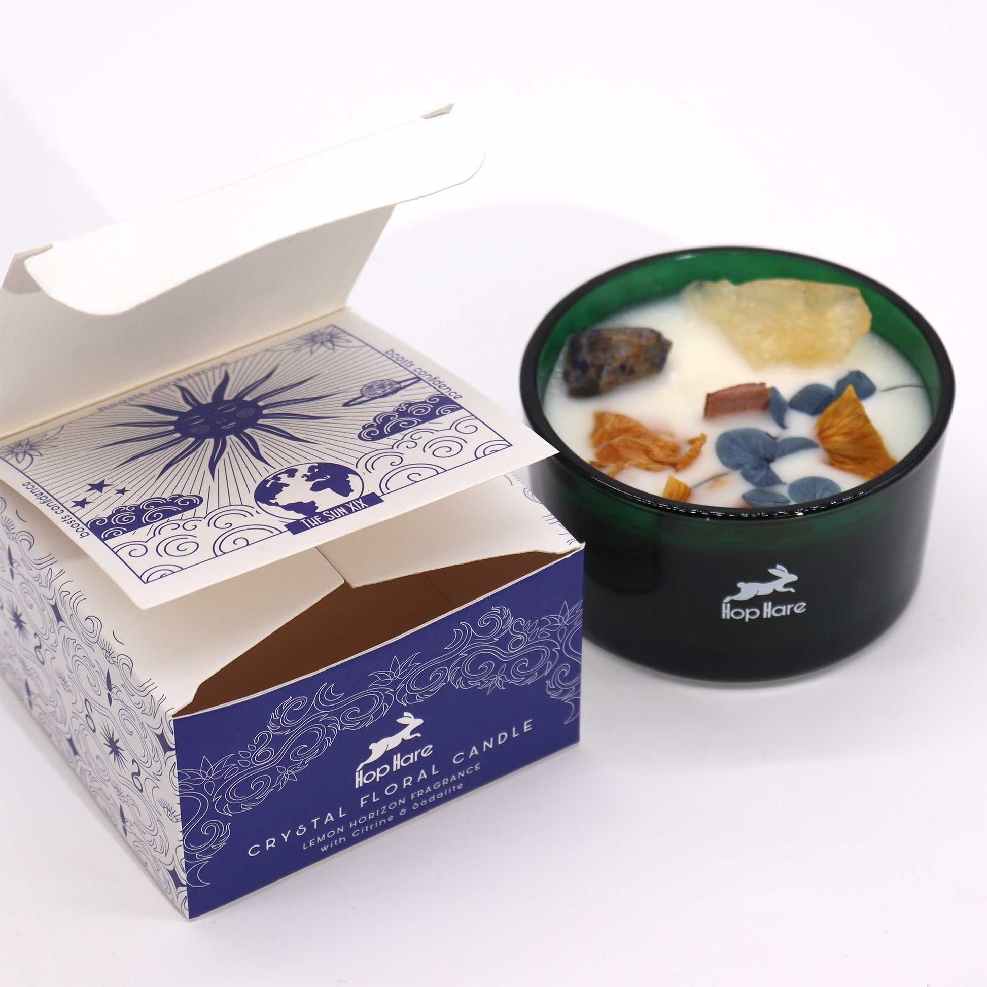 Alt Tag: Hope Hare Crystal Magic Flower Candle – The Sun i grön glasburk med dekorativa kristaller och blomvax, bredvid märkesförpackning