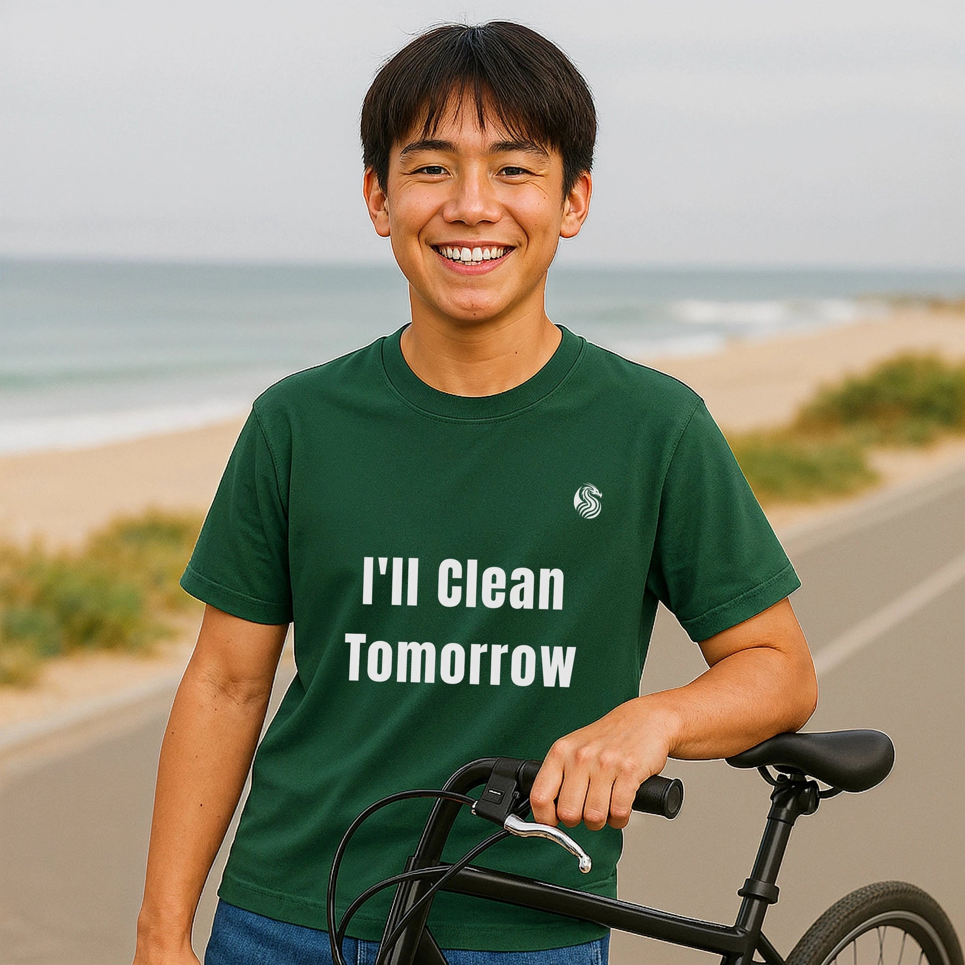 I'll Clean Tomorrow Teen Premium Unisex T-Shirt verde con texto "I'll Clean Tomorrow" en modelo adolescente junto a una bicicleta en la playa
