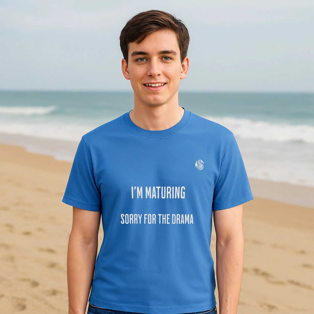 Alt Tag: I’m Maturing Teen Sustainable Unisex Tee blue graphic t-shirt with “I’M MATURING SORRY FOR THE DRAMA” text, worn at beach