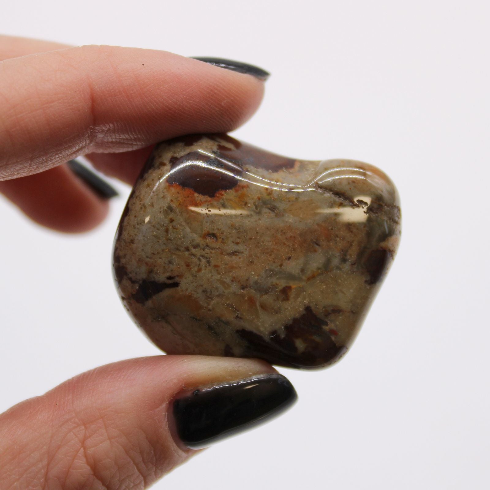 Jasper Nguni Gemstone Tumble Stones – Large Set of 6, piedra rodada pulida grande con vetas marrón y crema sostenida entre los dedos
