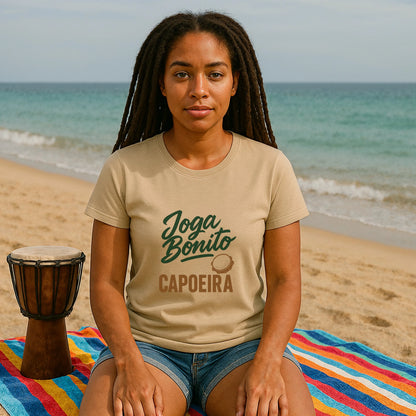 Joga Bonito Capoeria Sustainable Unisex Tee worn by woman sitting on beach, Joga Bonito capoeira graphic print on tan t-shirt
