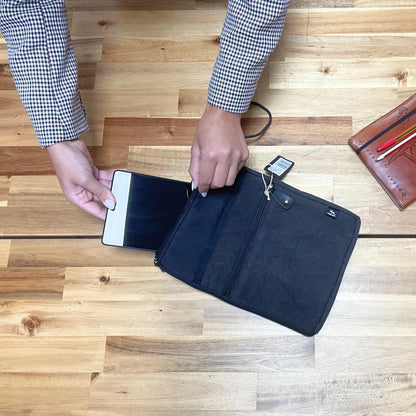Jute Cotton Tablet Pouch – Charcoal 21x29 CM with zipper, person sliding tablet into charcoal pouch on wooden table