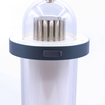 Lampe mit Flammeneffekt aus Kunststoff – Weiß, wiederaufladbar über USB‑C, Nahaufnahme des USB‑C‑Ladeanschlusses und der Bedientaste an der weißen Kunststofflampe