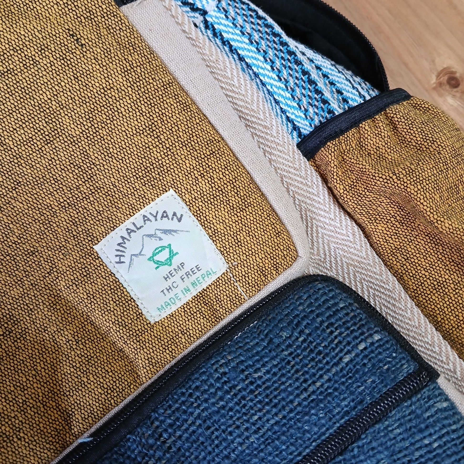 Alt Tag: Large Boxy Hemp Backpack – Teal & Turmeric close-up of hemp and cotton fabric, teal and turmeric panels, zipper pocket and label