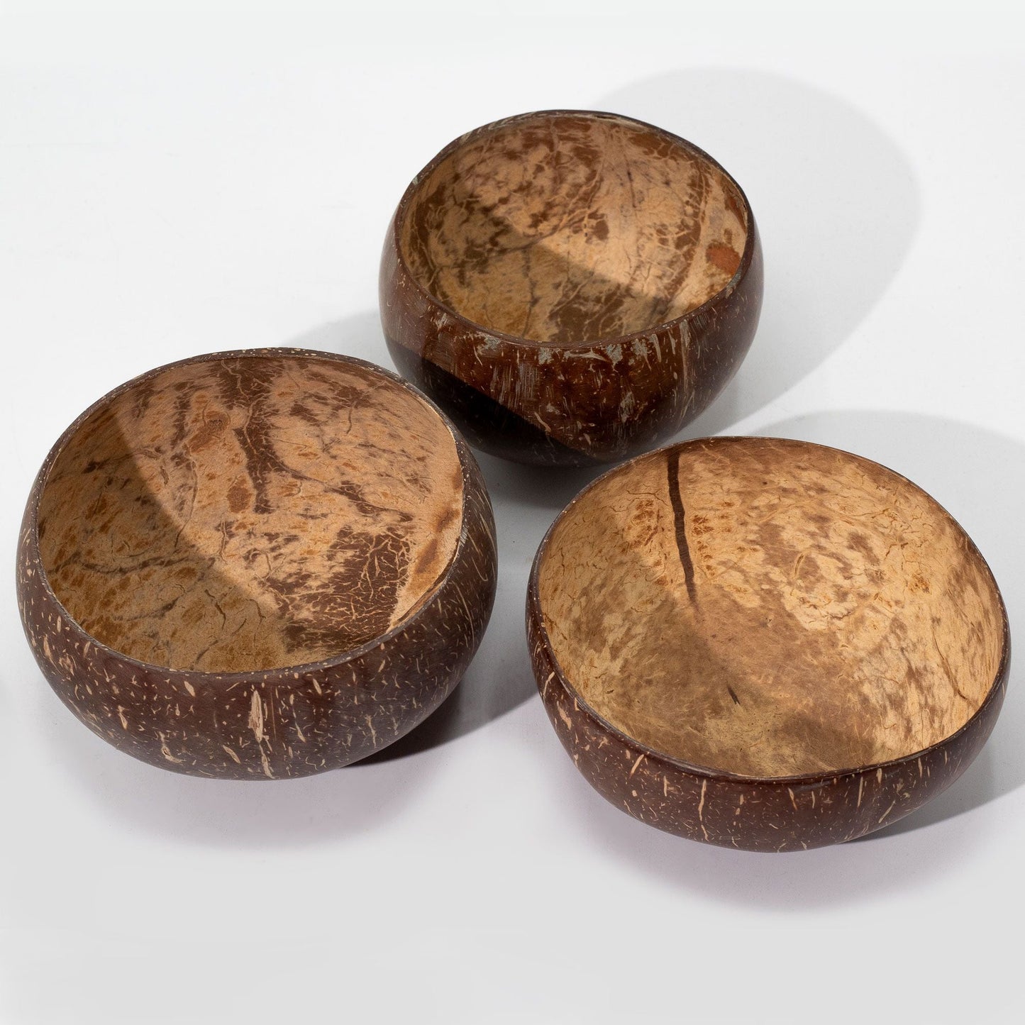 Stor Natural Coconut Bowl – set med tre handgjorda skålar av återvunna kokosnötskal med naturlig ådring och textur på vit bakgrund