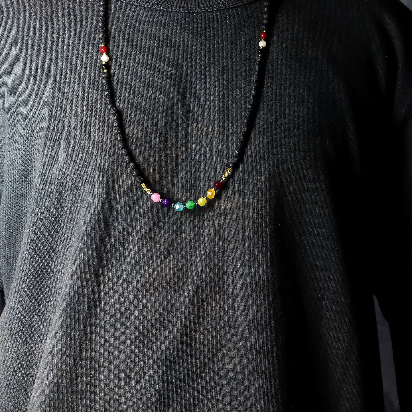 Lava Stone 7-Chakra Necklace – Emotional Harmonizing con cuentas de piedra volcánica y cristales de colores, collar unisex sobre camiseta negra