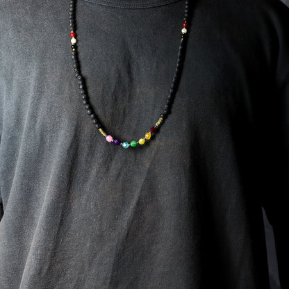 Lava Stone 7-Chakra Necklace – Emotional Harmonizing con cuentas de piedra volcánica y cristales de colores, collar unisex sobre camiseta negra