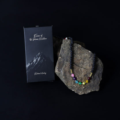 Alt Tag: Lava Stone 7-Chakra Necklace – Emotional Harmonizing with chakra crystal beads on rock, shown with black gift box