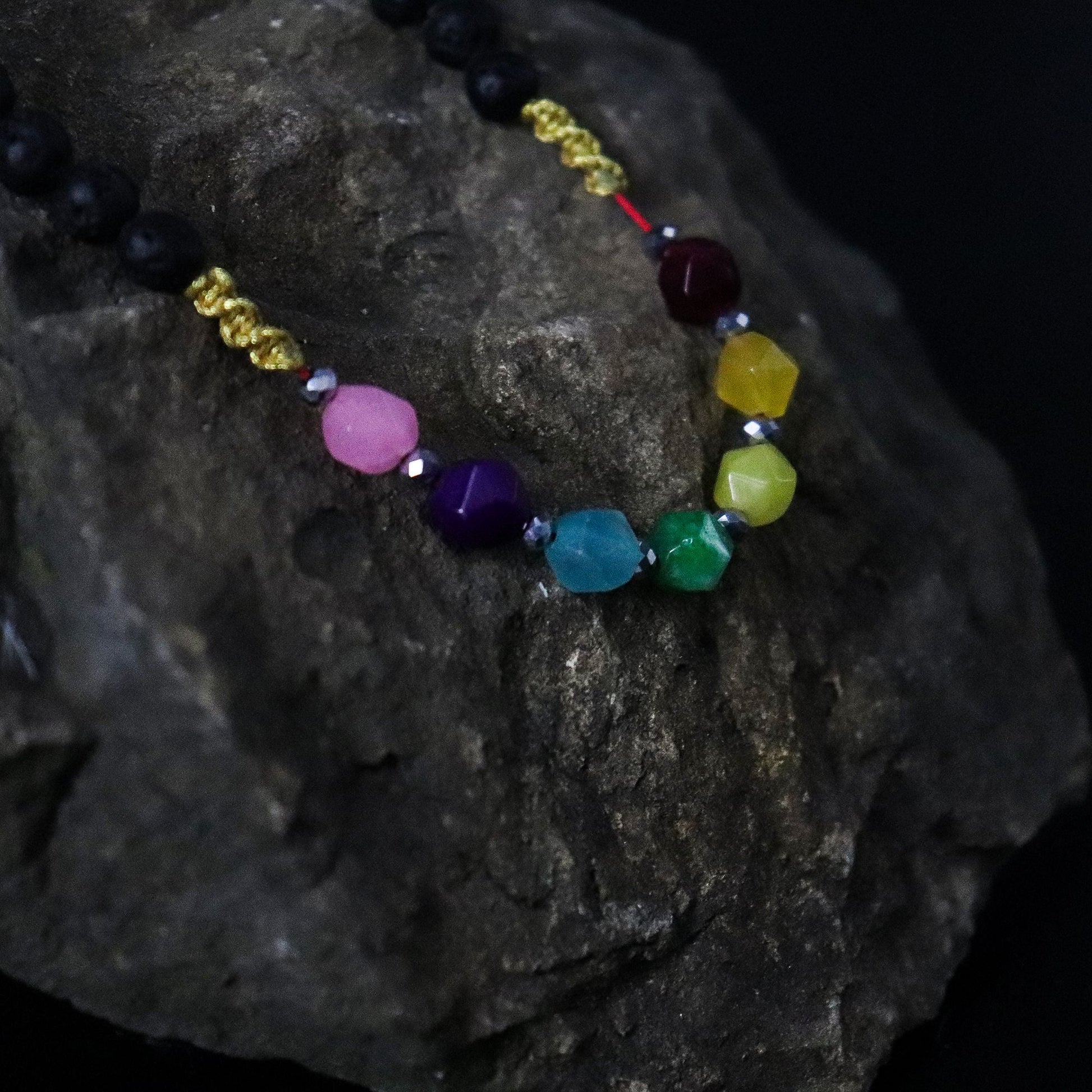 Alt Tag: Lava Stone 7-Chakra Necklace – Emotional Harmonizing with lava stone beads and multicolor chakra crystals on dark rock background