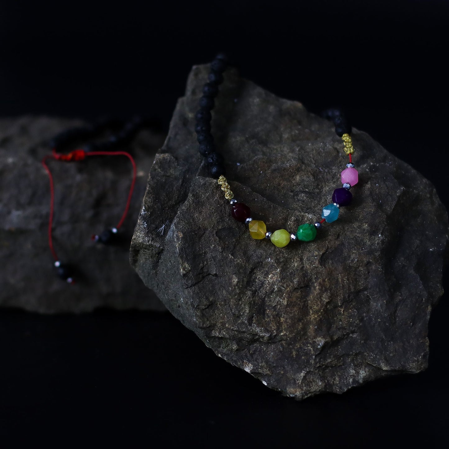 Lava Stone 7-Chakra Necklace – Emotional Harmonizing with black lava beads and multicolor chakra crystal strand on dark rock