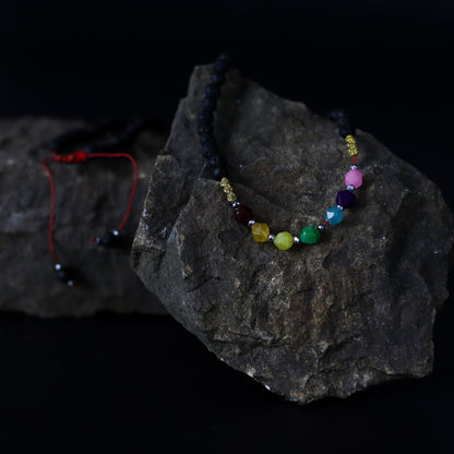 Lava Stone 7-Chakra Necklace – Emotional Harmonizing with black lava beads and multicolor chakra crystal strand on dark rock