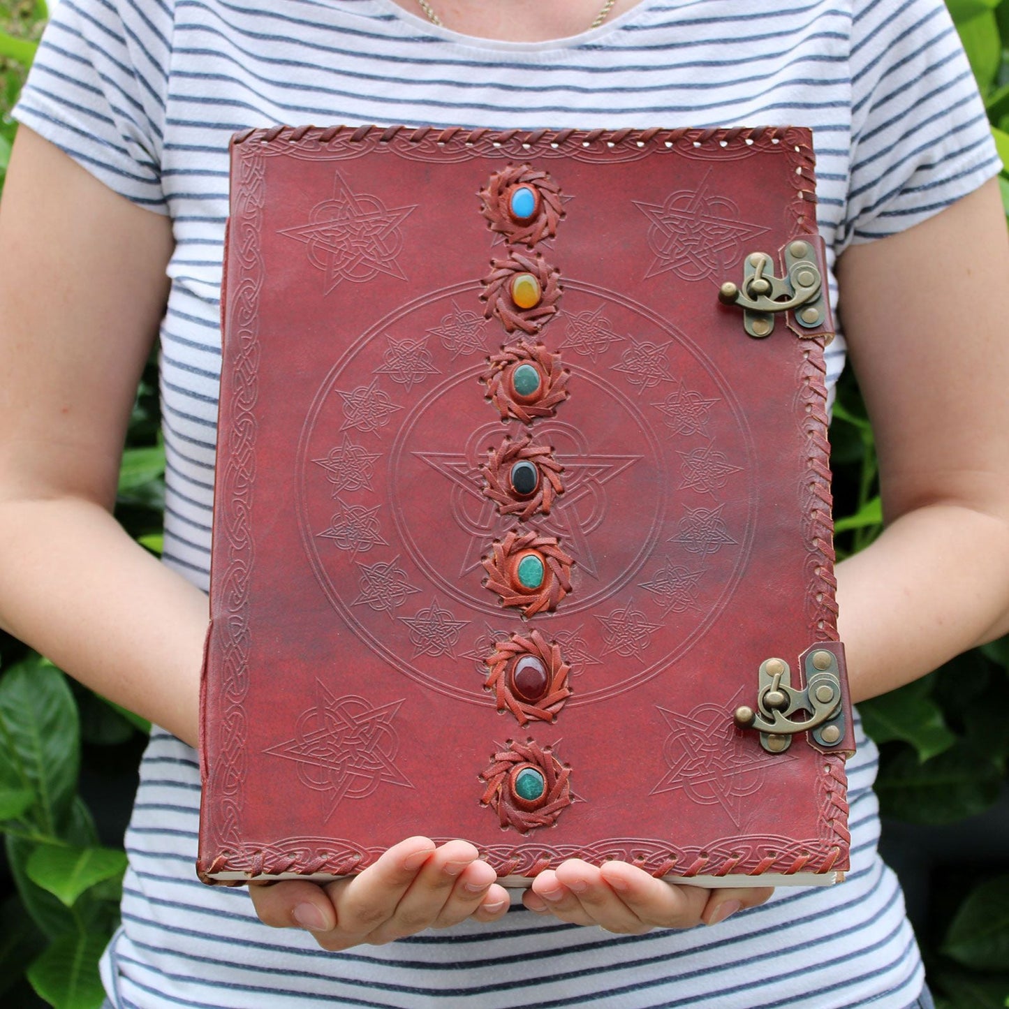 Alt Tag: Leather Chakra Journal – Huge 10x13, 200 Pages genuine leather notebook with chakra stones, embossed cover and metal clasp, held in hands