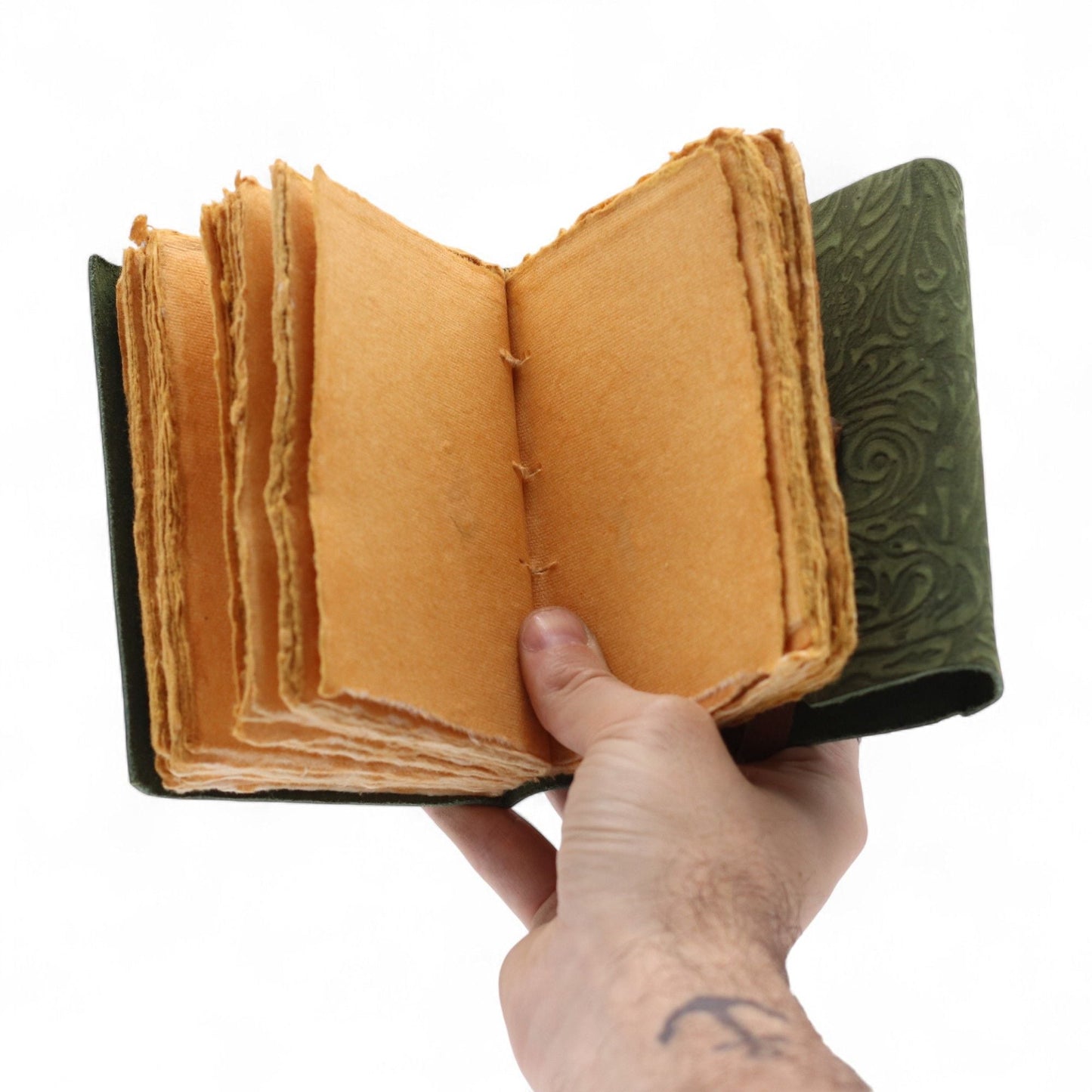 Alt Tag: Leather Notebook – Green Maze 12.7 x 8.9 CM open leather journal with deckled-edge pages and embossed green cover in hand