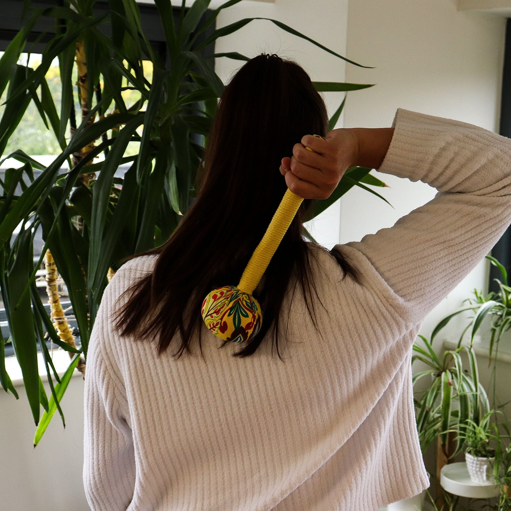 Lemon Wormwood Massage Hammer – Wooden Tool in use for rhythmic tapping massage on upper back at home