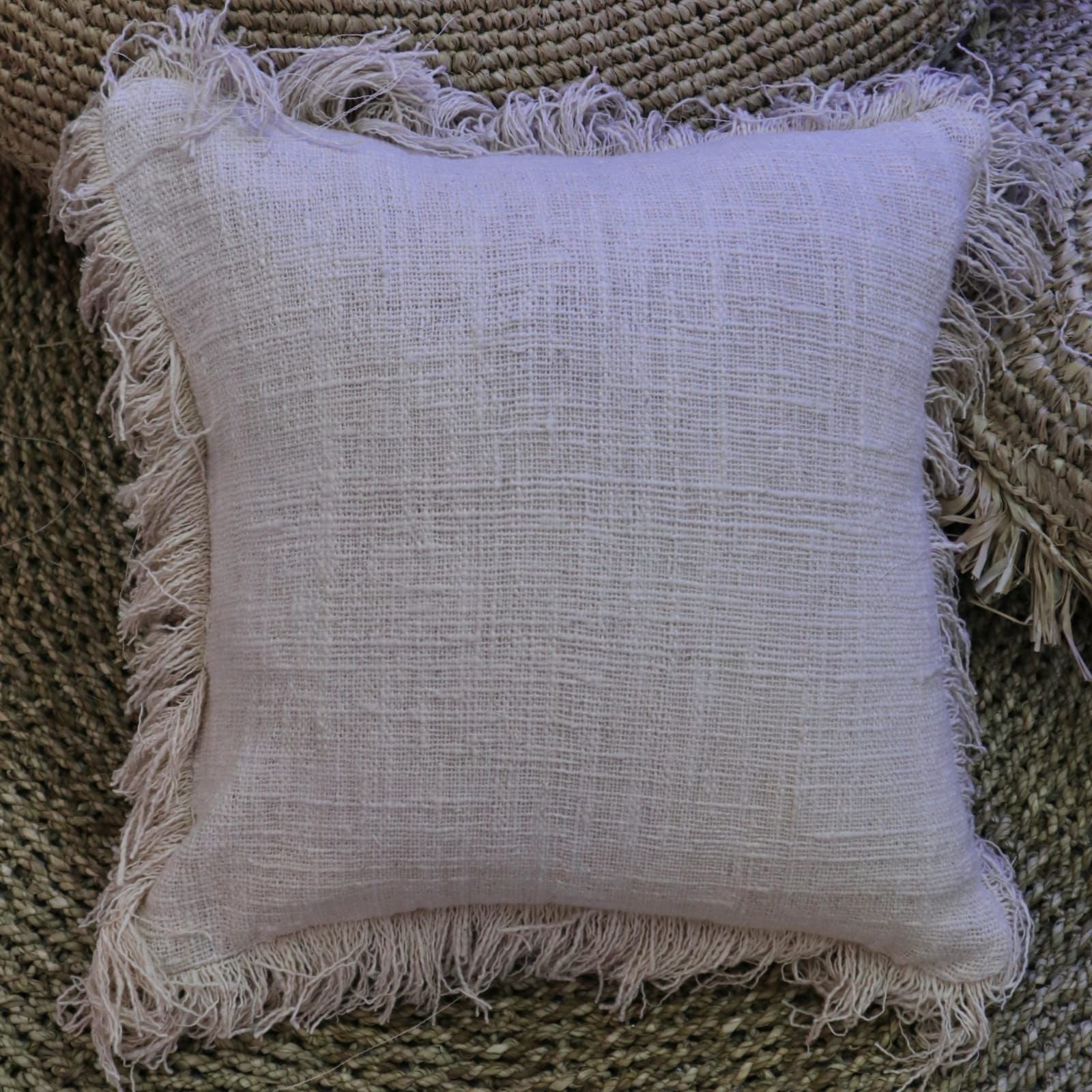 Alt Tag: Linen Cushion – Fringe Polos 60x60 CM beige linen cushion with fringe trim on textured woven rug