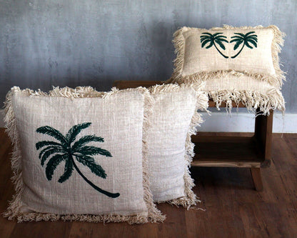 Linen Palm Tree Cushion – 45x45 CM beige linen-cotton cushion with embroidered palm tree and fringed edges, styled on floor and chair