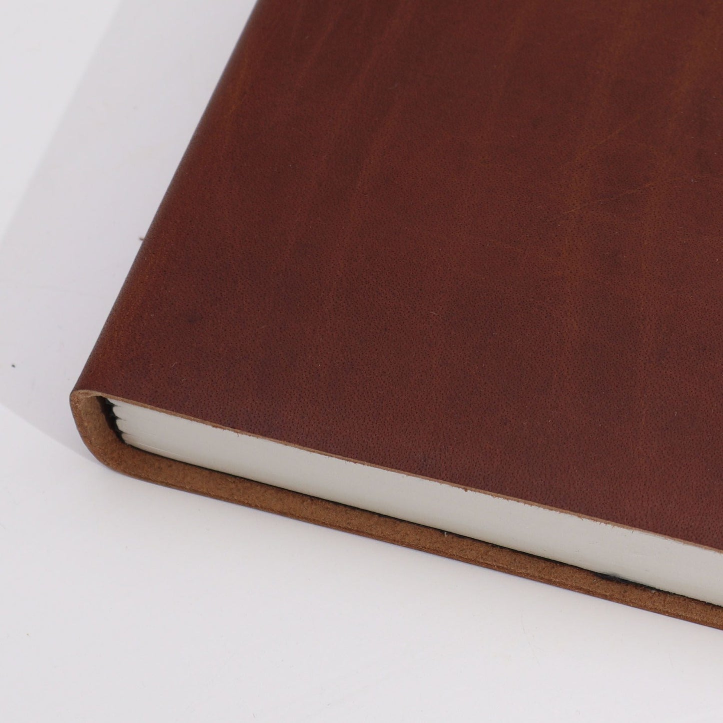Luxurious Leather Notebook – 100 Lined Pages, 20x15 CM brown leather cover close-up, handcrafted notebook edge and pages