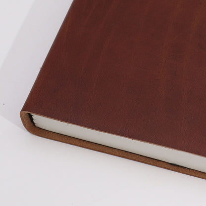 Luxurious Leather Notebook – 100 Lined Pages, 20x15 CM brown leather cover close-up, handcrafted notebook edge and pages