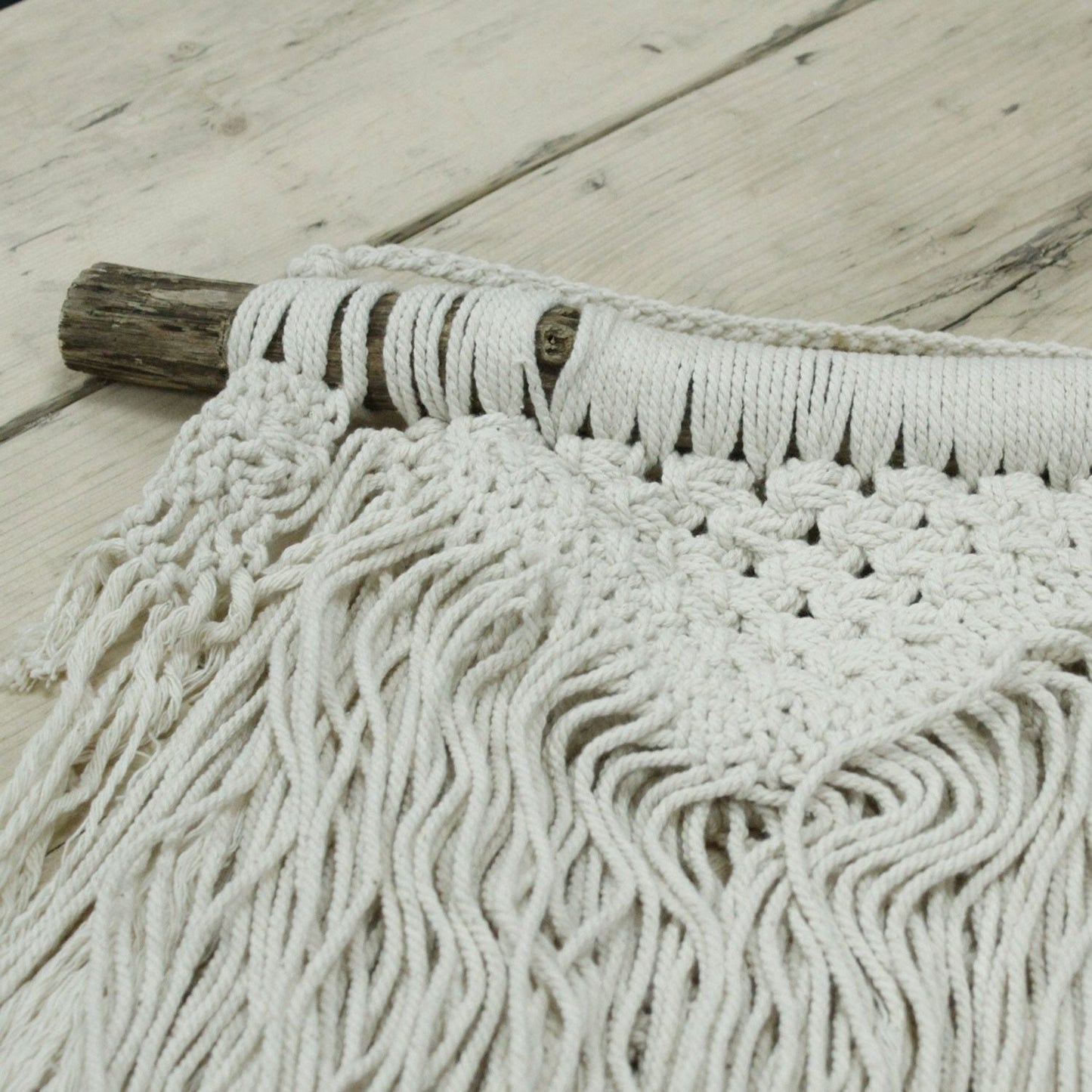Alt Tag: Macramé Wall Hanging – Natural Abundance in natural cotton with fringe and knotted detail on rustic wooden dowel