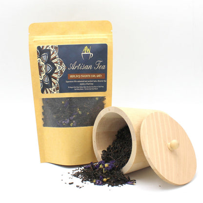 Mallow-Infused Earl Grey Tea – 50G Loose Leaf bolsa de té a granel con hojas negras y flores de malva junto a tarro de madera