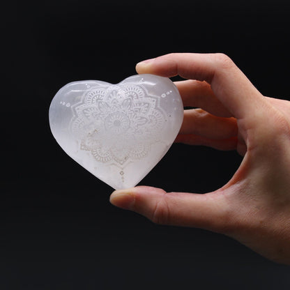 Alt Tag: Mandala Engraved Selenite Heart – 7–8 CM, corazón de selenita blanco translúcido con grabado mandala sostenido en la mano