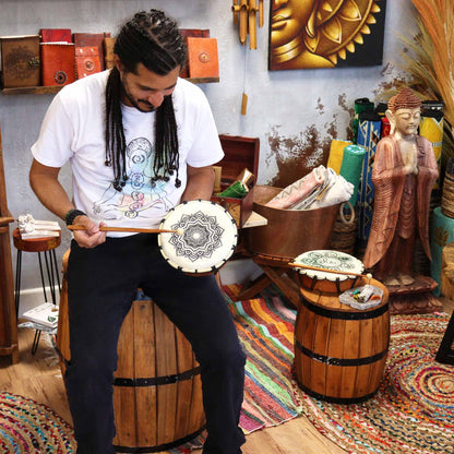 Mandala Shamanic Drum with Sticks – 20 CM handheld drum with mandala design, shown being played in a spiritual decor setting