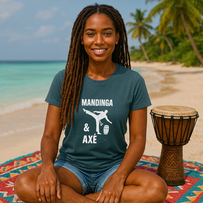 Alt Tag: Modelo con Mandinga Axe Capoeira Premium Unisex T-Shirt azul, diseño “Mandinga & Axé”, sentada en playa junto a tambor