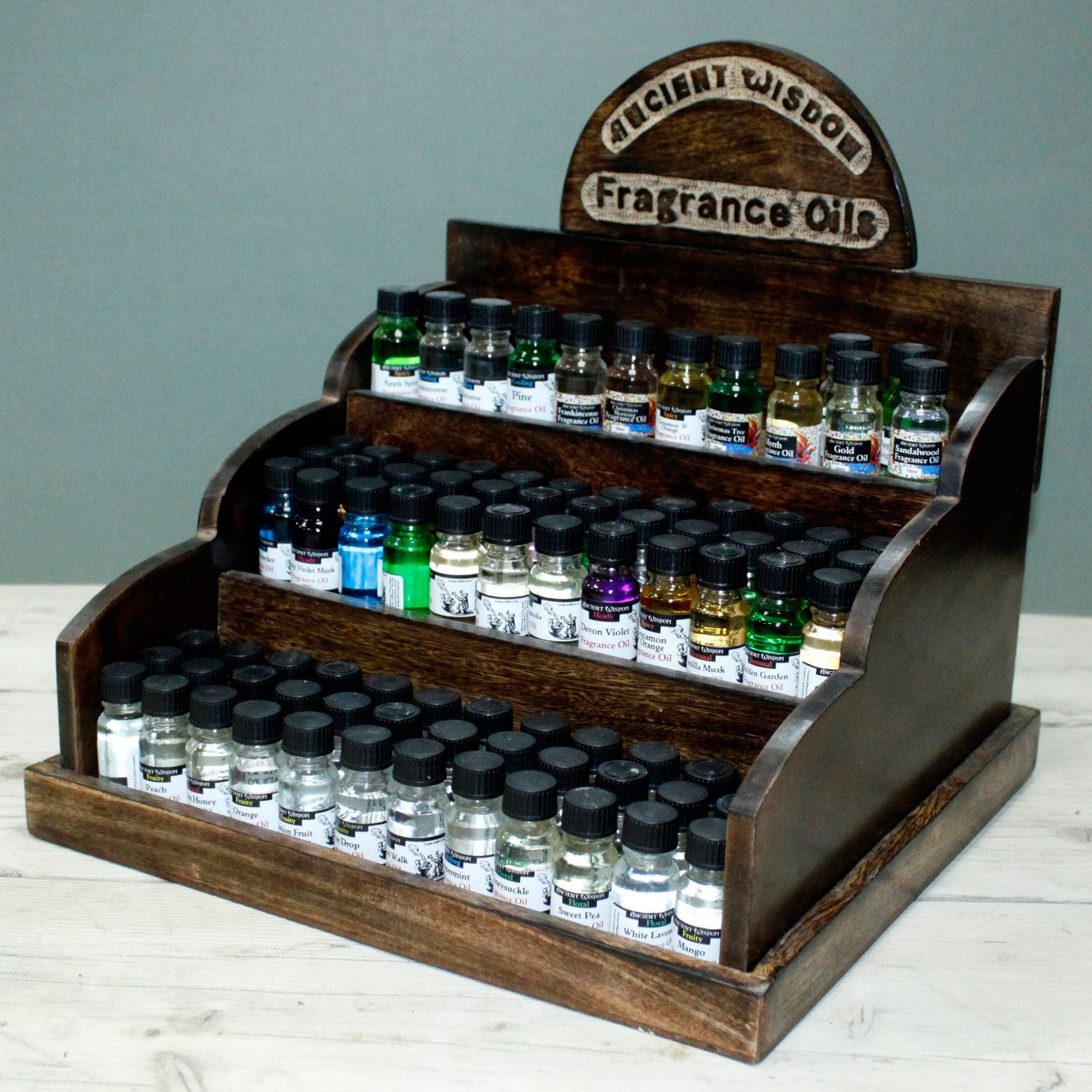 Alt Tag: Mango Wood Retail Display Stand – 36x33x34 CM tiered wooden counter display stand holding small fragrance oil bottles