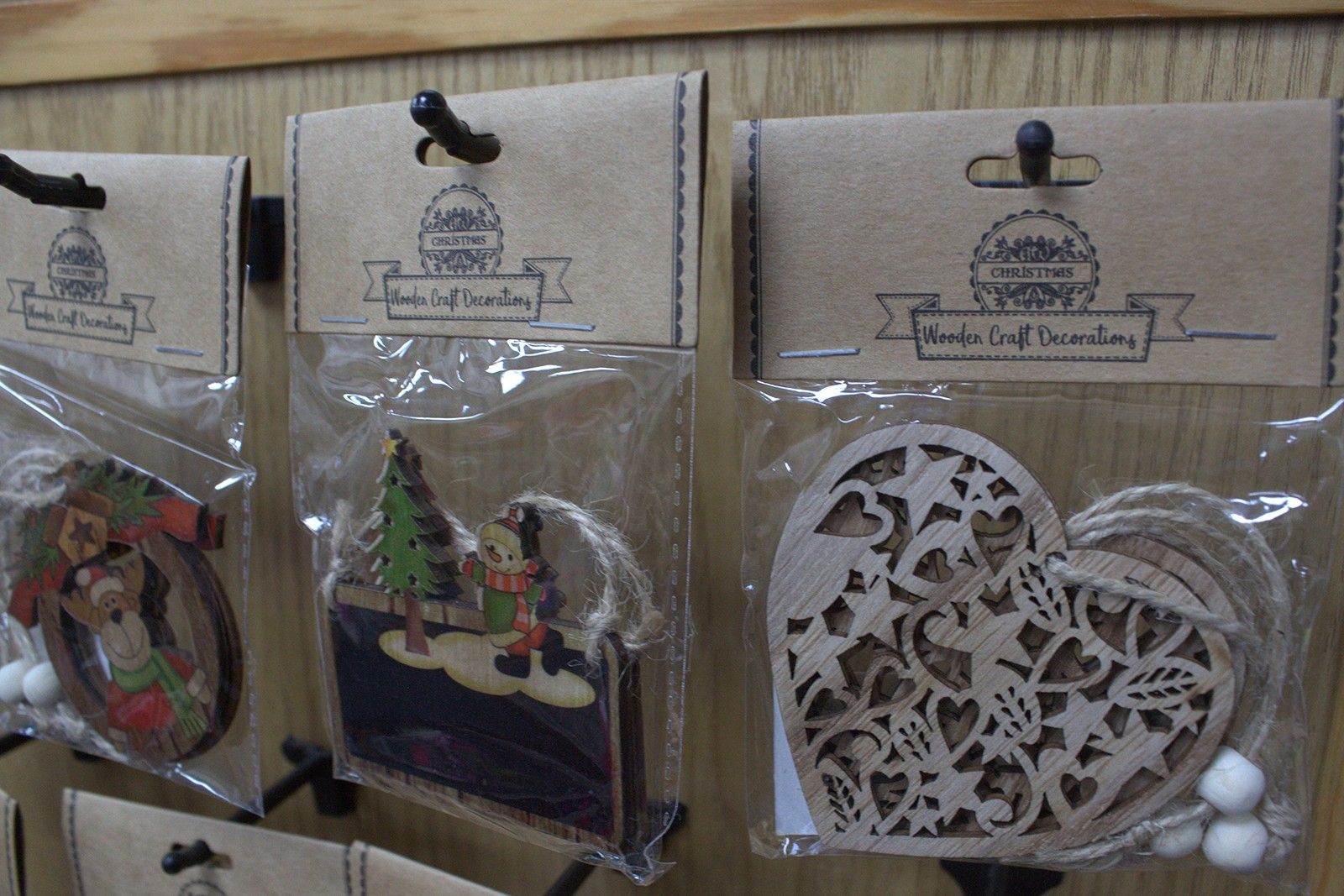 MDF Christmas Décor – Snowman & Tree Set packaged wooden ornaments on display, snowman and tree designs in clear bags