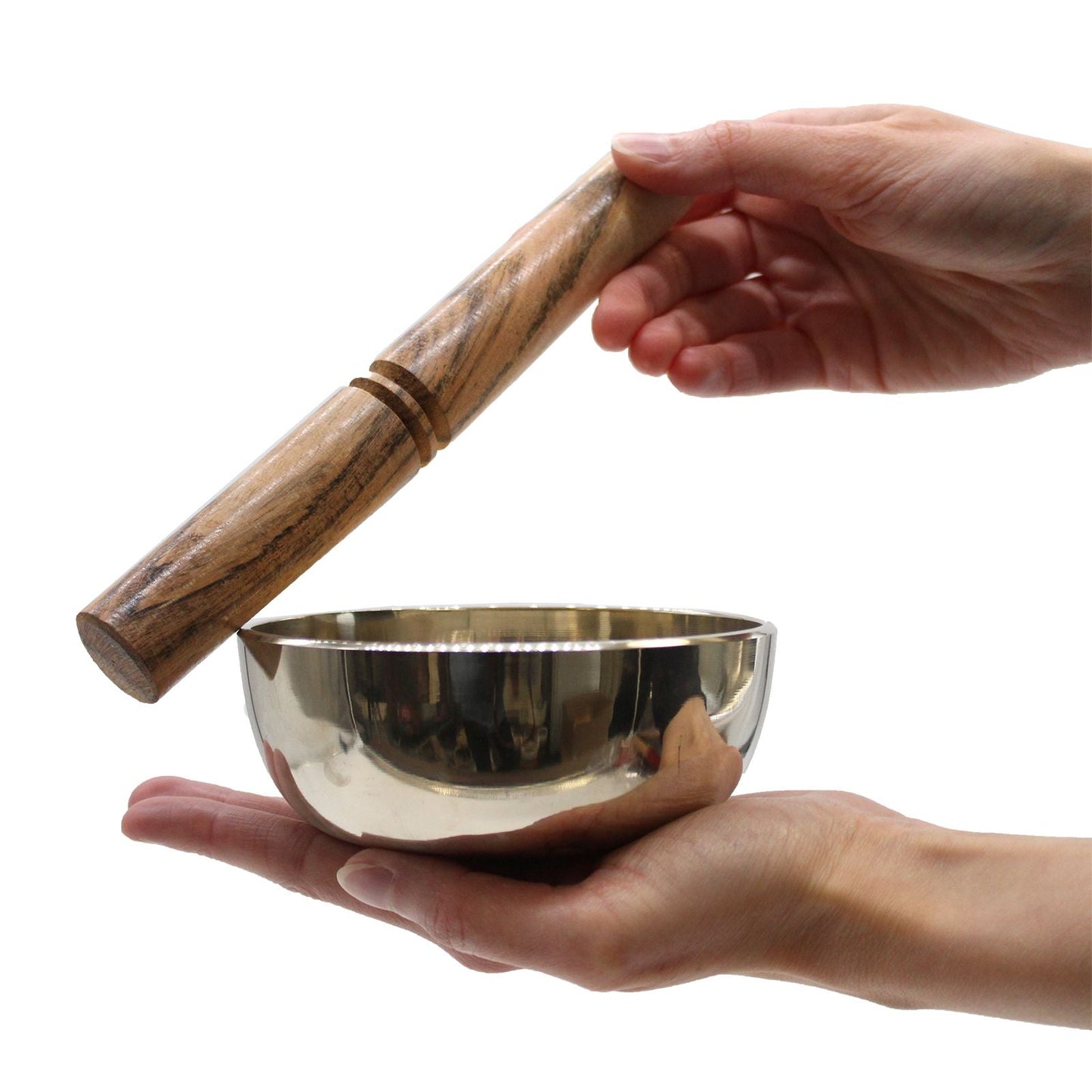 Alt Tag: Cuenco tibetano de latón mediano – cuenco de latón de 12 CM con mazo de madera sostenido en las manos, primer plano sobre fondo blanco