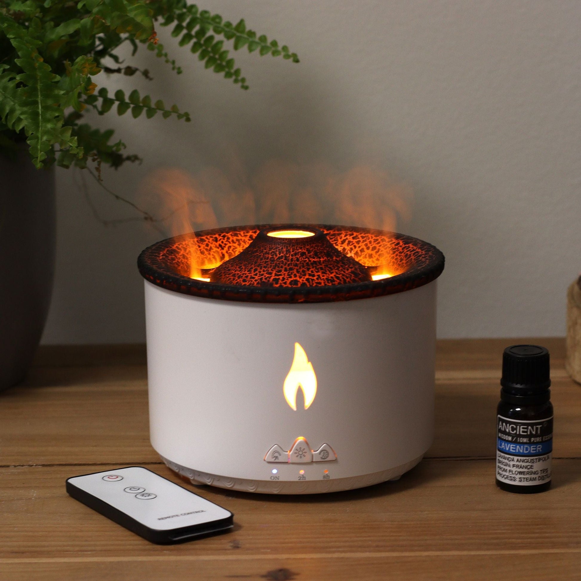 Medium aromadiffuser med Volcano Effect (kontakt) – två färger på bord med vulkanliknande dimma, fjärrkontroll och flaska med eterisk olja