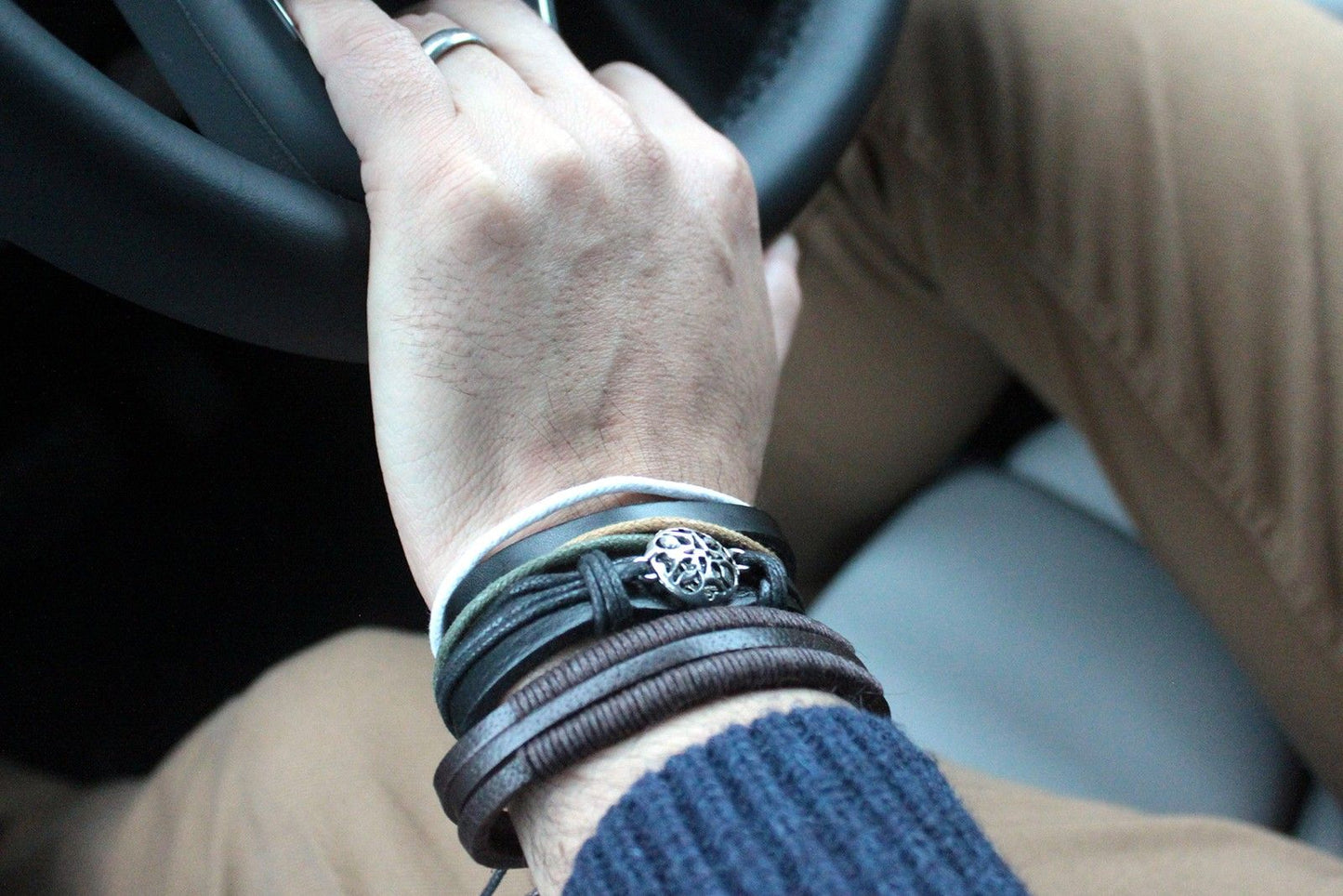 Alt Tag: Men’s Bracelet Set – Metal & Leather (Assorted) on wrist, layered leather bands with metal charm and braided strap