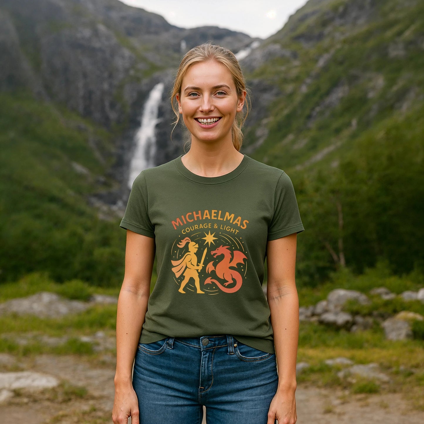 Michaelmas Courage Ans Light 100% Organic Cotton T-Shirt worn by woman outdoors, green tee with Michaelmas Courage & Light graphic