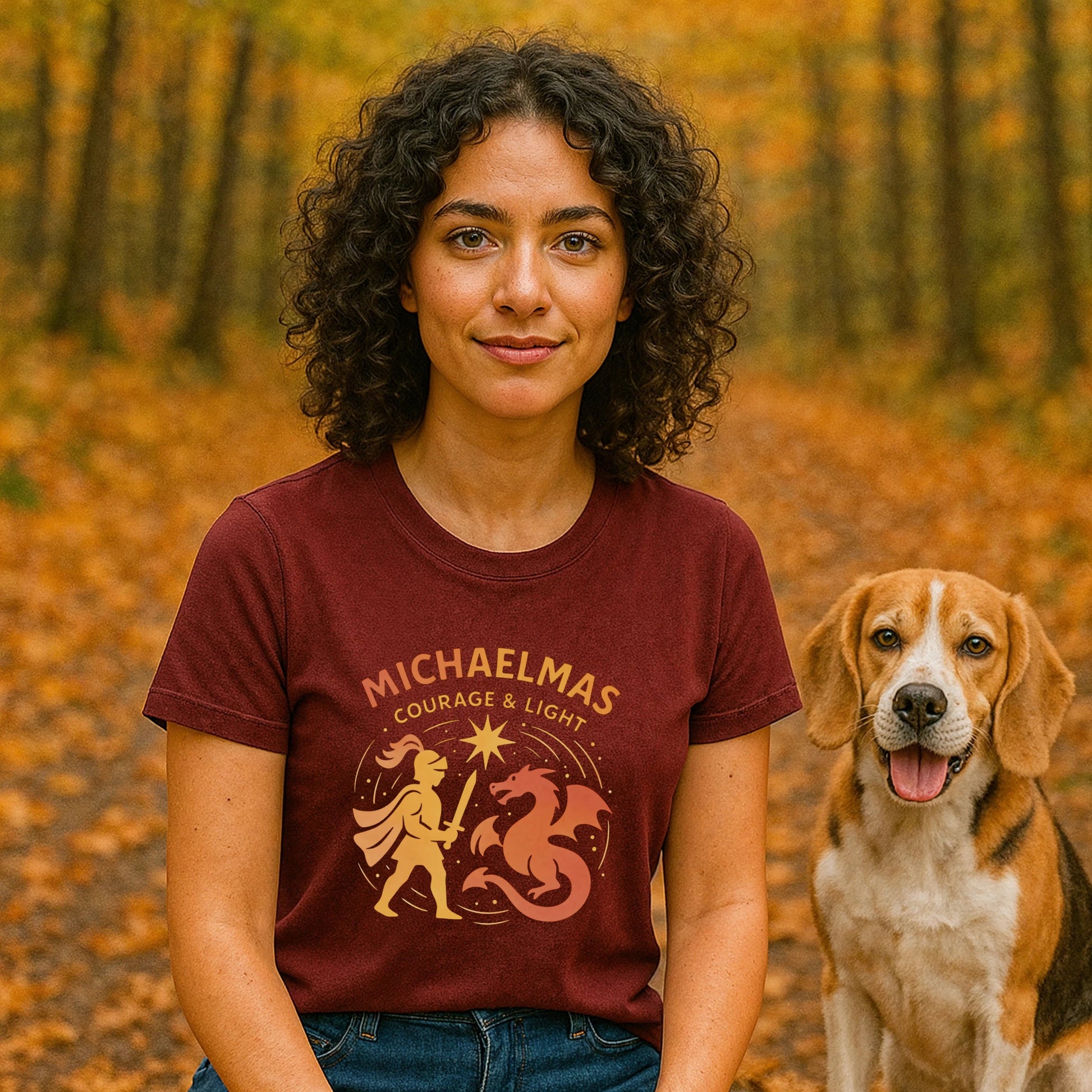 Michaelmas Courage Ans Light 100% Organic Cotton T-Shirt worn by woman in autumn forest, maroon tee with Michaelmas Courage & Light graphic