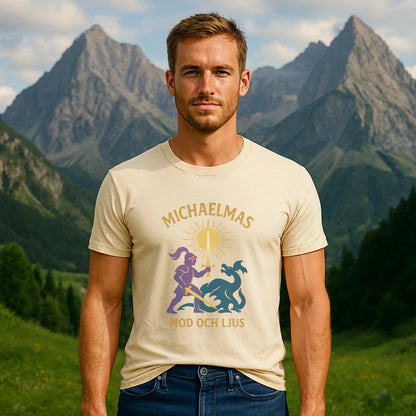 Michaelmas Mod Ljus 100% Organic Cotton T-Shirt worn by male model, cream graphic tee with Michaelmas print, outdoors with mountains