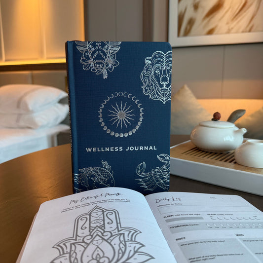 Midnight Blue Journal – Silbernes Sternzeichen, 120 Seiten Mitternachtsblaues Wellness-Journal mit silbernem Sternzeichen-Cover auf einem Tisch, aufgeschlagene Seiten im Vordergrund