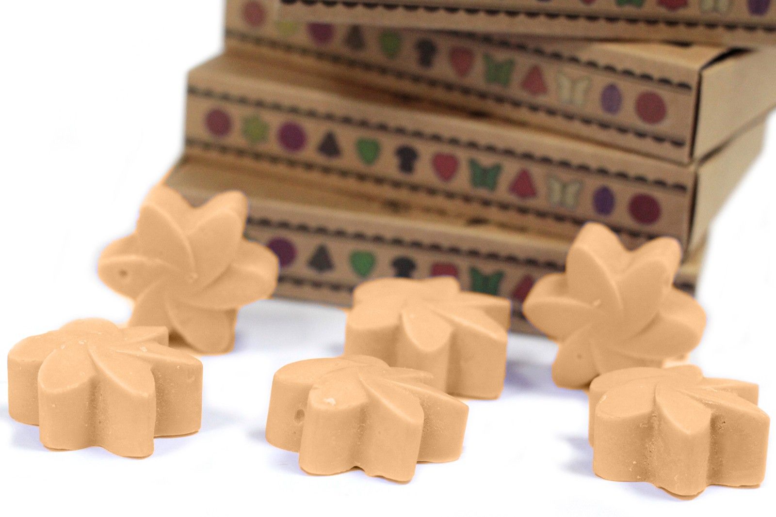 Wax melts i soja- & palmvax – Midnight Jasmine 6-pack, sex blomformade wax melts på vit bakgrund med en kartonglåda i bakgrunden