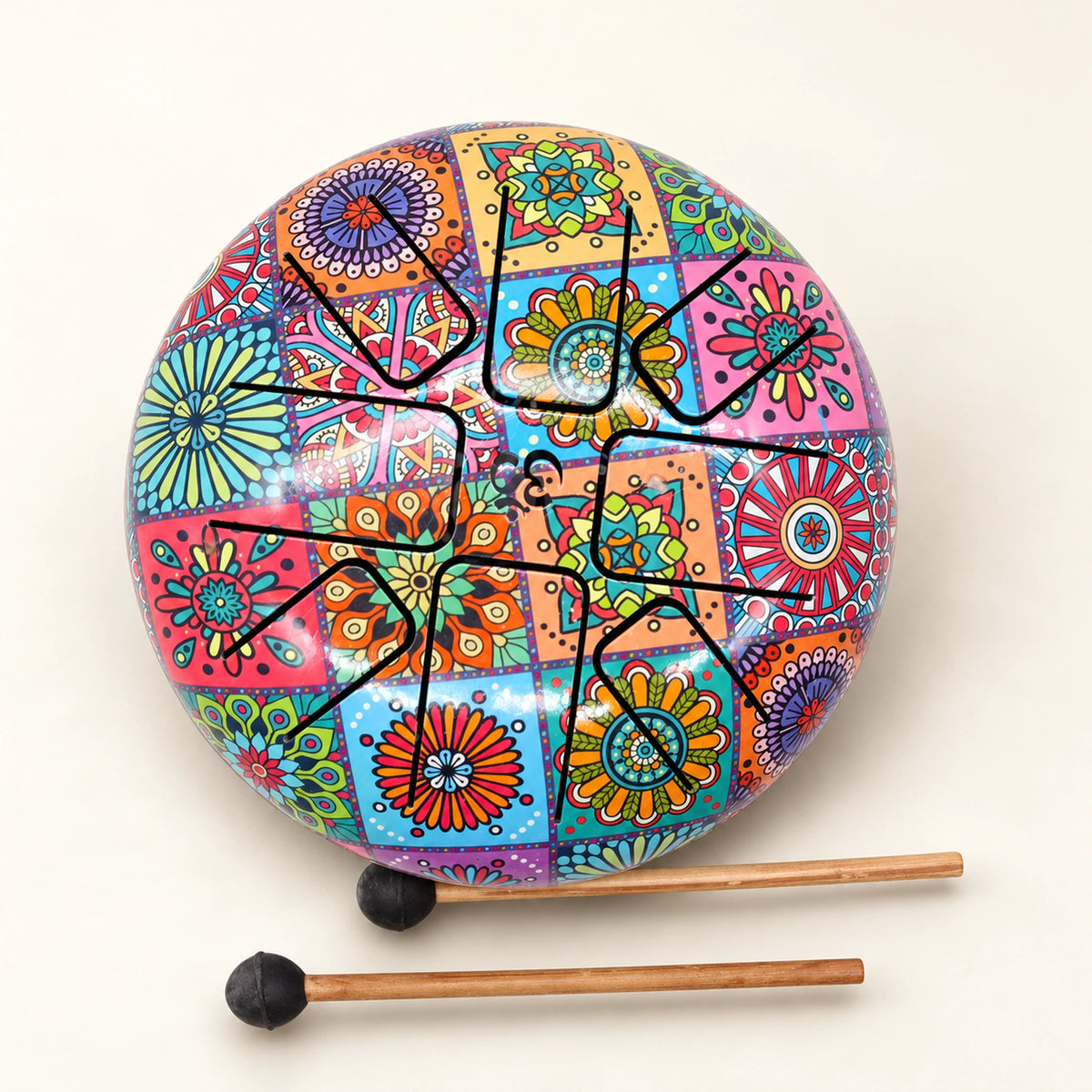 Glossy steel tongue drum with colourful floral panels and two black-headed mallets on an ivory background.