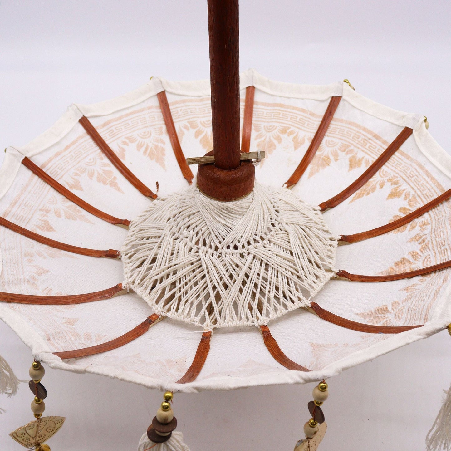 Alt Tag: Natural Canvas Bali Parasol – 40 CM de tela canvas natural con varillas de madera, detalle interior artesanal y colgantes decorativos