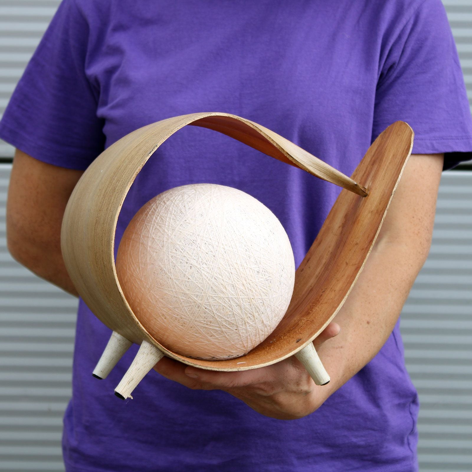 Alt Tag: Natural Coconut Leaf Lamp – Unique Loop Design handcrafted coconut leaf loop lamp with cotton shade, held in hands
